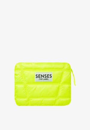 Neon yellow padded laptop sleeve with a textured quilting pattern and a black label prominently displaying "SENSES .THE LABEL." Zipper closure.