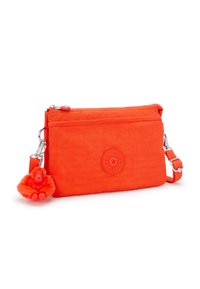 Orange nylon tværgående taske med lynlås, prydet med et rundt logo og en lodden abe charm hængende fast med en sølvclip.