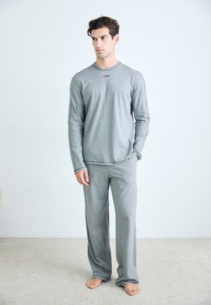 Graues Langarmoberteil und passende Hose aus weichem Stoff, mit einem schlichten Design und einem kleinen Logo auf der Brust.