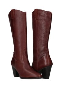 Bruine leren laarzen tot de knie met een puntige neus en een gestapeld hak. Beschikt over een gladde textuur en decoratieve stiksels langs de schacht.