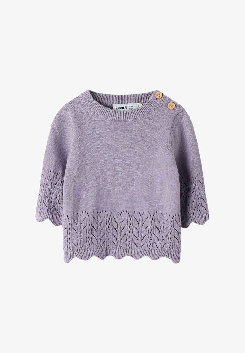Pull en tricot lilas à manches courtes, avec un ourlet festonné et un motif de feuilles en bas. Deux boutons beiges à l'épaule.