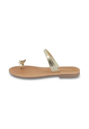 Gold metallic flat sandals with a toe post and ankle strap. Smooth leather footbed with stitching detail. Decorative accent at toe post.