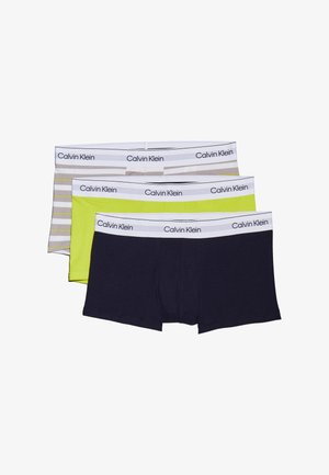 Tres pares de calzoncillos tipo bóxer de Calvin Klein: uno de color sólido azul marino, otro de color verde lima brillante y otro con un patrón de rayas grises, todos con cinturillas blancas con el logo.