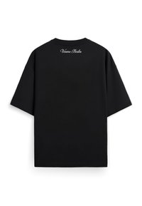 Μαύρο φαρδύ T-shirt που φαίνεται από πίσω με κοντά μανίκια και λευκό κείμενο με καλλιγραφική γραμματοσειρά "Vertere Berlin" κοντά στο λαιμό.