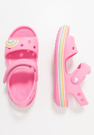 Růžové dětské sandály vyrobené z lehkého gumového materiálu, s dekorací duhy, nastavitelným páskem a barevnými pruhovanými podrážkami.