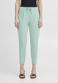 Menta gröna joggerbyxor med mjuk textur, elastisk midja, dragsko och sidfickor, taperad bendesign.