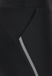 Zwarte sportleggings met een soepele textuur, een schuine naadontwerp en een contrasterende grijze streep aan de zijkant voor detail.