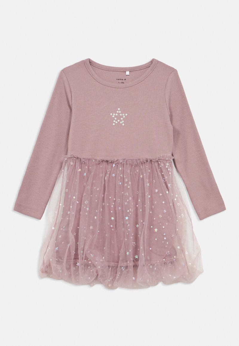 Φόρεμα με μακριά μανίκια, ροζ τοπ με ραμμένες ρίγες και φούστα από στρώσεις τούλι, που διαθέτει ασημένια μοτίβα αστεριών και ένα έμβλημα αστεριού στο σώμα.