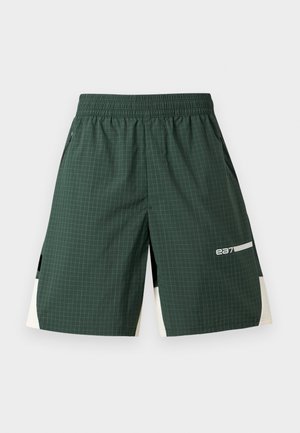 Temno zelene športne kratke hlače z nežnim mrežastim vzorcem, elastičnim pasom, stranskimi žepi, belimi in črnimi barvnimi paneli ter logotipom "ea7" na levi nogi.