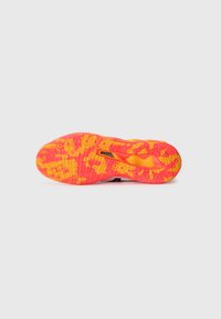 Lys orange og gul løbesko sål med tekstureret dækmønster og synlig mellemsål støtte struktur på hvid baggrund.