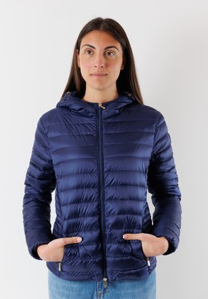 Giacca puffer blu navy con cappuccio, caratterizzata da un design trapuntato, chiusura con zip e tasche laterali. Testura liscia e lucida con dettagli in metallo.