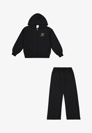 Felpa nera con zip e cappuccio, con un piccolo dettaglio grafico, abbinata a pantaloni tuta neri con vita elastica.