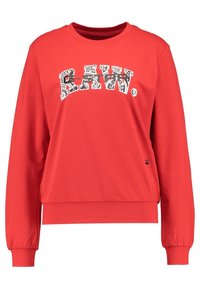Roter Pullover mit langen Ärmeln, Rundhalsausschnitt und einem bedruckten "R-RAW."-Logo in Schwarz und Weiß auf der Vorderseite. Hergestellt aus glattem Material.