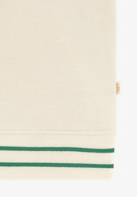 Beežikangaga, millel on sooniline ääreosa, millel on kaks rohelist horisontaalset triipu ning väikene beežikangast silt paremal pool.