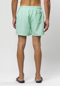 Világos menta zöld úszónadrág, rugalmas derékkal és egy hátsó zsebbek. Simma anyagú és egyenes szabású kialakítás.