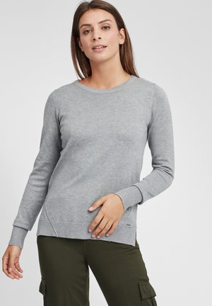 Grå langermet genser med rund hals, ribbete mansjetter og sidesplitt. Myk strikket materiale, kombinert med olivengrønne cargo bukser.