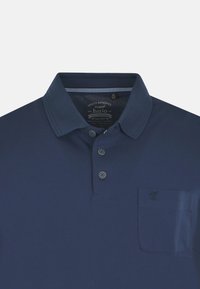 Granatowa koszulka polo z kołnierzykiem, trzema guzikami na przodzie i kieszonką na lewej piersi z detalem w postaci małego logo. Gładka tekstura.