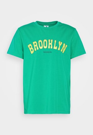 Green short-sleeve cotton T-shirt with yellow "BROOKLYN" text arched across the chest and small black "KANGOL" logo below.