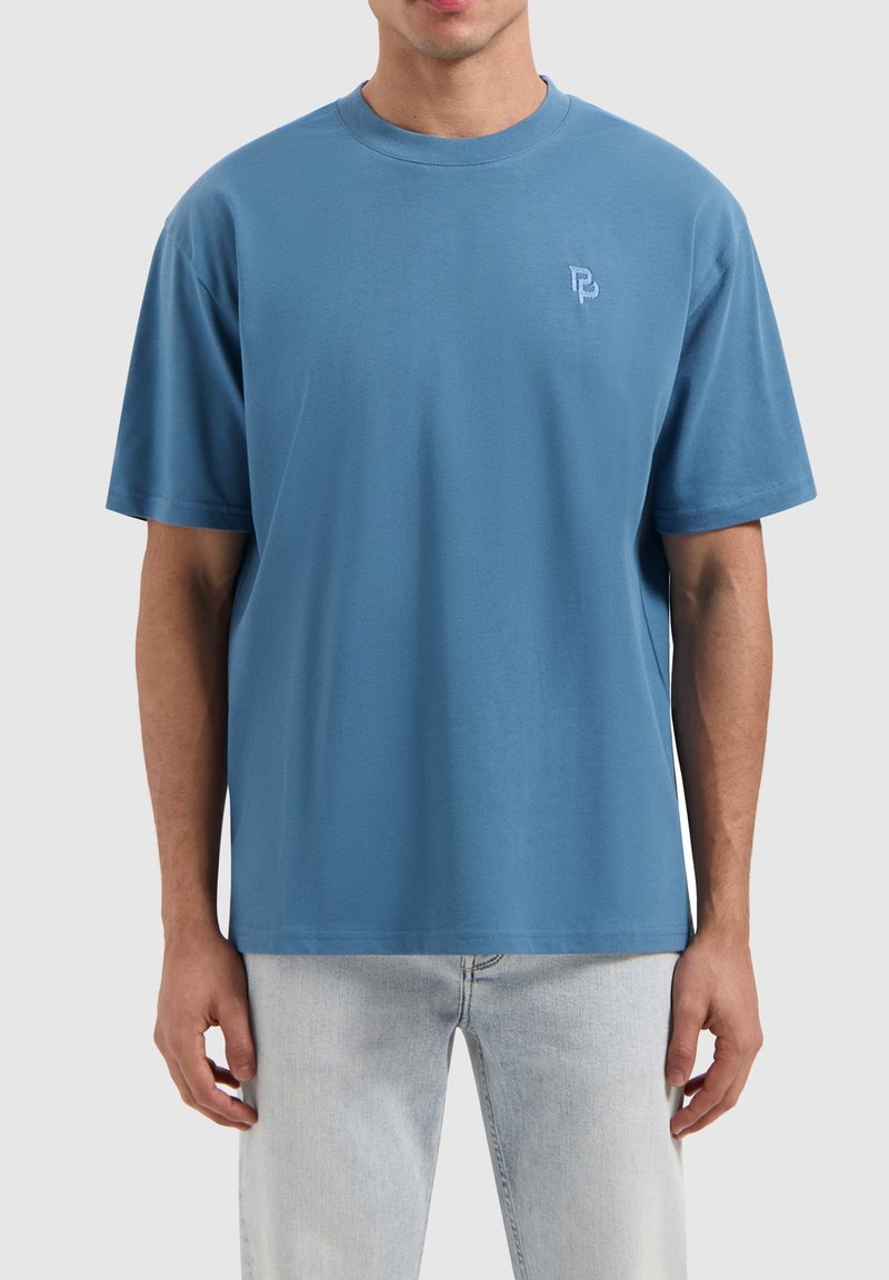 Blauwe t-shirt met korte mouwen gemaakt van zachte stof, voorzien van een ronde hals en een klein geborduurd logo op de linkerborst.