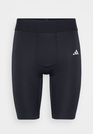 Sorte atletiske kompressionsshorts til knæet med bred talje og et lille hvidt Adidas-logo på venstre lår.