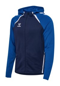 Veste de sport légère à capuche bleu et marine avec des accents blancs et une fermeture éclair à l'avant, comportant le logo hummel sur la poitrine.