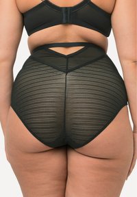 Sous-vêtements noirs taille haute en tissu transparent rayé, avec une ceinture élastique lisse et un design de découpe géométrique à l'arrière.