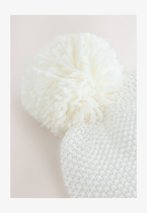 Berretto bianco lavorato a maglia con motivo a rilievo e pon pon soffice sulla sommità, realizzato con un filato morbido.
