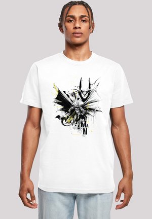 White cotton T-shirt featuring a black and yellow graphic of a figure with bat wings, detailed textures, and abstract splatters.