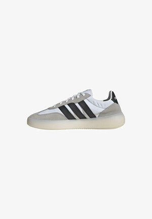 Zapatillas blancas con acentos de ante gris y tres rayas negras. Presentan una suela texturizada y un collar acolchado para mayor soporte.