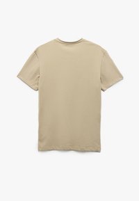 Lyhythihainen beige t-paita, joka on valmistettu puuvillasta. Siinä on klassinen pyöreä kaula-aukko ja sileä, tasainen pinta. Ei näkyviä kuvioita tai koristeita.