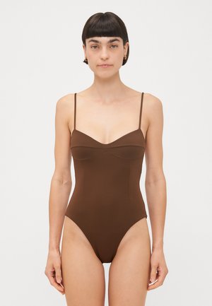 Brown one-piece swimsuit with thin straps, a sweetheart neckline, and high-cut legs. Smooth texture and sleek design, minimal detailing.
