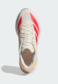 Light beige running shoe with red stripes, mesh textile upper, padded tongue, orange accents, and a cushioned sole for comfort.