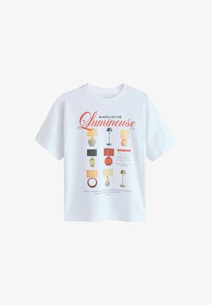 Vit bomulls-t-shirt med ett grafiskt tryck av olika lampdesigner i färger som gul, grön och röd, med orden "Simplicité Lumineuse."