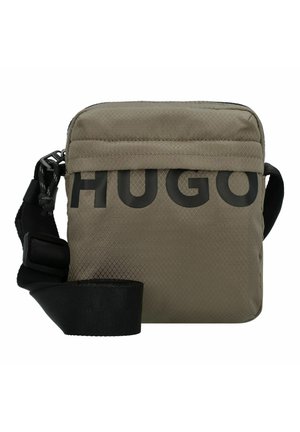 Kompaktowa oliwkowo-zielona torba na ramię z czarnym regulowanym paskiem i dużym czarnym logo "HUGO" z przodu.