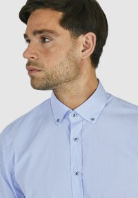 Lichtblauw geruit shirt met button-down kraag en contrasterende knopen, met een zachte textuur en een getailleerd ontwerp.