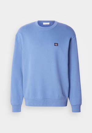 Lichtblauwe crewneck sweatshirt, gemaakt van zacht materiaal, voorzien van ribgebreide mouwen en onderrand, met een klein logo-opdruk op de bovenste linkerzijde.