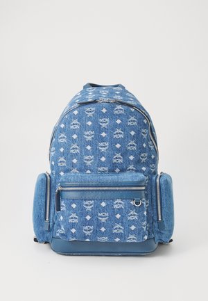 Sac à dos en denim bleu avec un motif de logo répété, deux zips, une poche avant et des compartiments latéraux rembourrés pour un rangement supplémentaire.