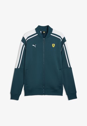 Türkisfarbene Sportjacke mit Reißverschluss, weißen Schulter- und Ärmelstreifen, Puma-Logo auf der linken Brust und gelbem Ferrari-Schild auf der rechten Brust.