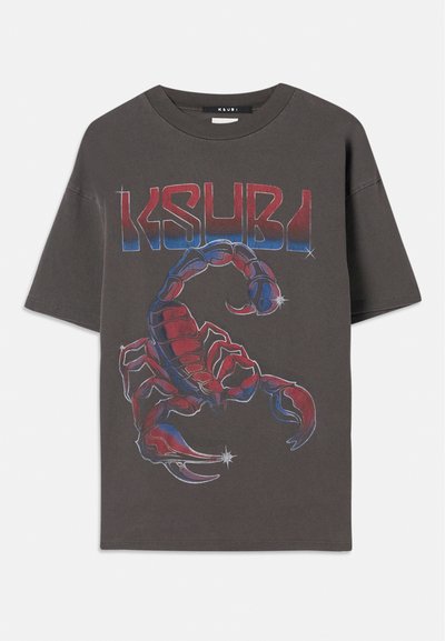 Harmaa ylipitkä t-paita, joka on valmistettu puuvillasta ja jossa on värikäs skorpioni-kuvio sinisillä ja punaisilla yksityiskohdilla. Yllä rohkealla fontilla "KSUBI" -teksti.