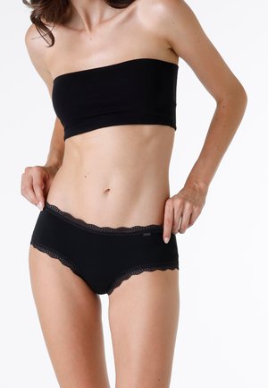 Top nero senza spalline e boyshort coordinati con bordi in pizzo. Il tessuto è liscio con un sottile lucido e presenta bordi in pizzo a scalloped.