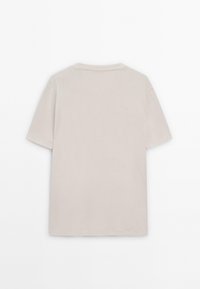 T-shirt a maniche corte con collo tondo in cotone beige chiaro. Texture liscia, design semplice, senza motivi visibili o dettagli hardware.