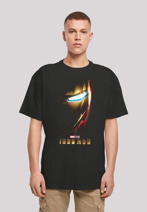 Black cotton t-shirt featuring an Iron Man graphic with a close-up of the helmet, highlighted in red and gold accents, and bold text below.