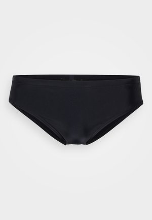 Shorts de bain noirs en tissu lisse et extensible, avec un design taille basse et des coutures minimales pour un ajustement confortable. Pas de matériel visible.