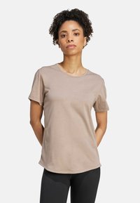 Ljusbrun bomulls-t-shirt med korta ärmar, rund halsringning och subtil logodetalj. Mjuk textur, avslappnad passform och rak nederkant.