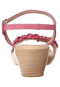 Pink suede sandals with a back strap, floral accent details, and a light wood grain wedge heel. Smooth insoles with minimal texture.