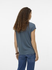 Kortermet t-skjorte med rund hals i dyp blått stoff, avslappet passform, glatt tekstur, kombinert med blå denimjeans, uformell stil.
