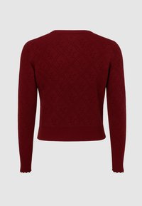 Maglione a maniche lunghe di un rosso scuro con un motivo a rombi caratterizzato da iniziali "YZ" in rilievo ripetute su uno sfondo semplice.