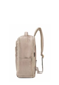 Beżowy plecak wykonany z wytrzymałego materiału, z boczną kieszenią, siateczkowymi paskami dla wygody oraz zamykaną na zamek komorą główną.
