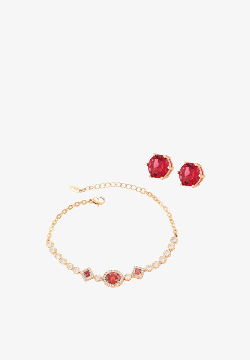 Złota bransoletka z czerwonymi i białymi kamieniami szlachetnymi obok pasujących kolczyków z czerwonymi kamieniami szlachetnymi na białym tle.