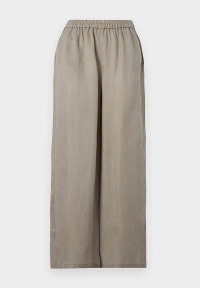 Ανοιχτό καφέ παντελόνια φαρδιάς γραμμής με ελαστική μέση και πλαϊνές τσέπες, εμφανίζονται πάνω σε μονόχρωμο φόντο.